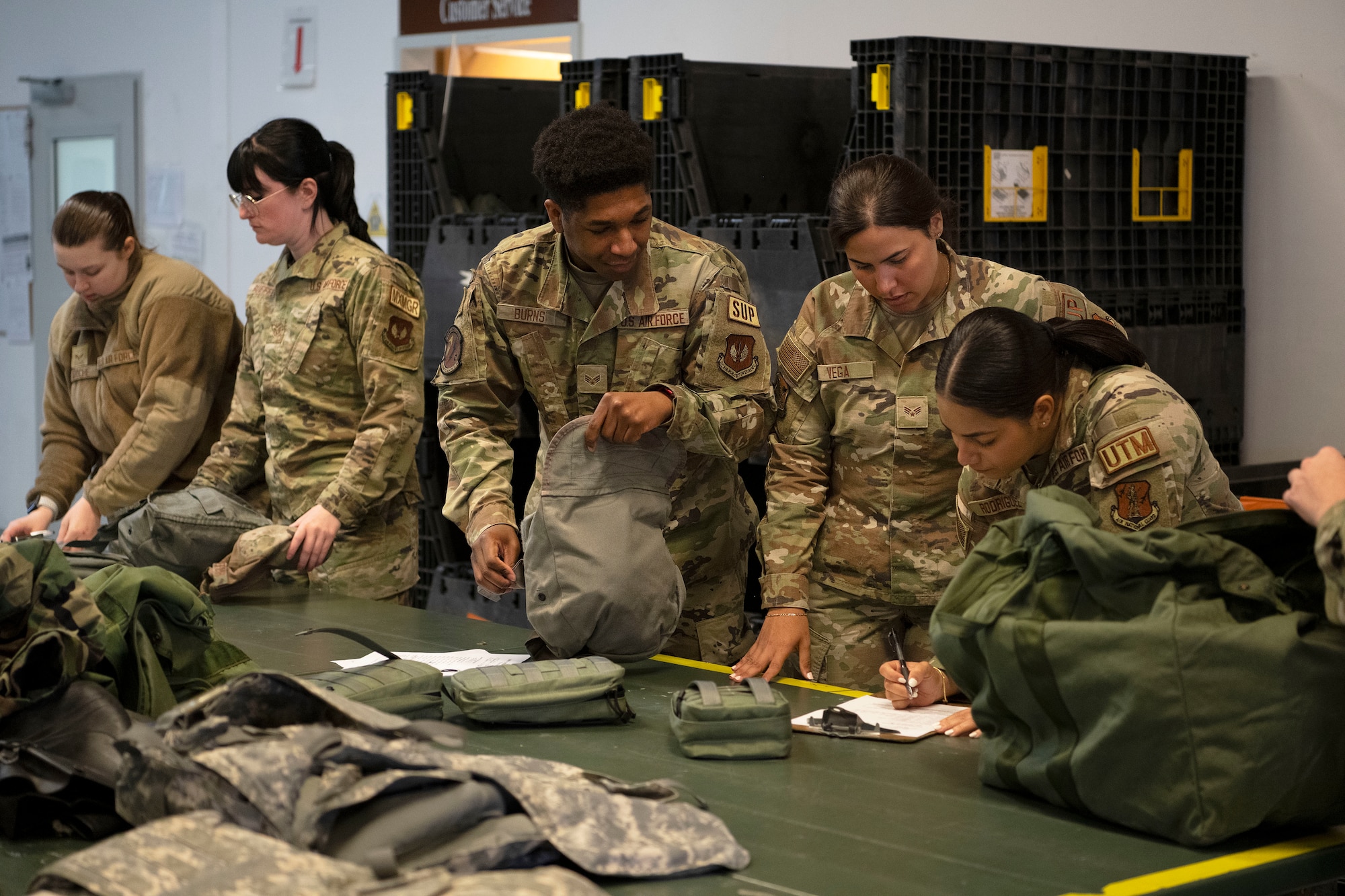 U.S. Air Force Senior Airman Dorian Burns, a material management journeyman assigned to the 52nd Logistics Readiness Squadron, Senior Airman Alondra Vega, a material management journeyman and Senior Airman Stephanie Rodriguez, a material management journeyman, both assigned to the 156th Logistics Readiness Squadron, Puerto Rico Air National Guard, review mission oriented protective posture training gear and checklists at Spangdahlem Air Base, Germany, May 6, 2024. Saber Knight Readiness Exercise 24-01 incorporated lessons learned from previous exercises and tested the 52nd Fighter Wing’s ability to rapidly generate F-16 Fighting Falcon sorties; execute base defense operations during simulated threats including chemical, biological, radiological, and nuclear (CBRN) attacks; and further develop and execute command, control, and communication (C3) tactics in support of contingency and war-time operations. (U.S. Air National Guard photo by Master Sgt. Rafael D. Rosa)