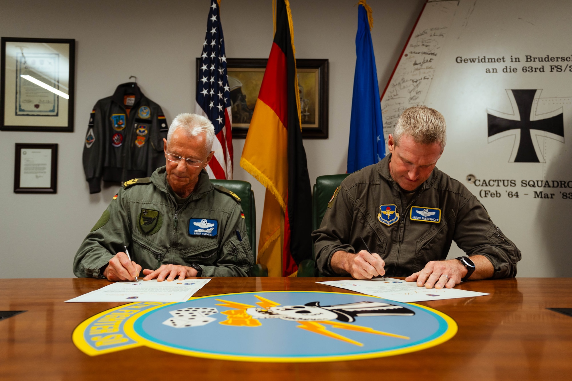 German Air Forces Maj. Gen. Peter Klement (left), GAF’s Flying Unit commander, and U.S. Air Force Brig. Gen. Jason Rueschhoff (right), 56th Fighter Wing commander sign a decree of honor between the Airmen of the 310th Fighter Squadron and the 2nd Flying Squadron of the Tactical Air Wing 33