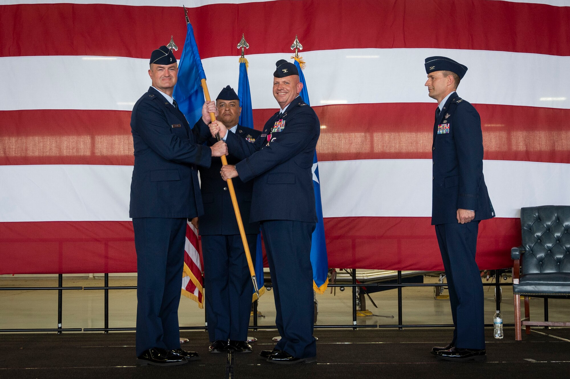 U.S. Air Force Col. Kevin Davidson (middle), former 47th Flying Training Wing (FTW) commander, turns over the 47th FTW guidon to Brig. Gen. Randall Cason (left), Mobilization Assistant to the Commander, Nineteenth Air Force, during the 47th FTW change of command ceremony at Laughlin Air Force Base, Texas, June 26, 2024. As commander, Davidson oversaw nearly 2,800 military and civilian personnel engaged in executing more than 61,000 aircraft sororities yearly in support of Laughlin’s Undergraduate Pilot Training mission. (U.S. Air Force photo by Senior Airman Kailee Reynolds)