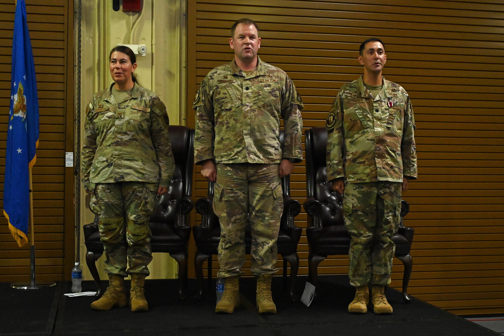 Three colonels stand on a podium and sing the Air Force song.