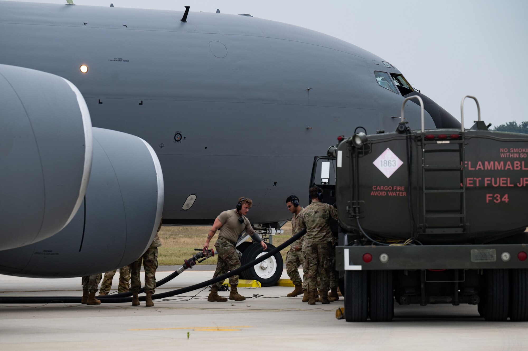people standing by fuel truck and KC-135