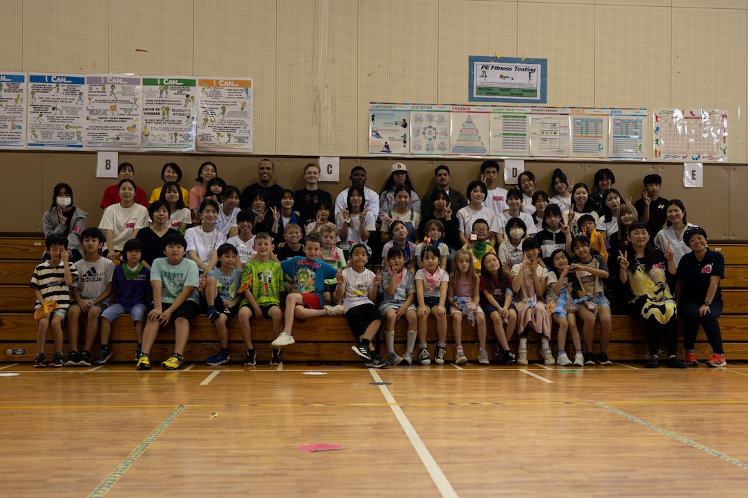 Participants pose for a group photo during a Host Nation Summer Program event on Camp Kinser, Okinawa, Japan, June 22, 2024. This program hosted a cultural exchange that included challenges and games for U.S. Marine volunteers from the Kinser Single Marine Program, local Okinawa volunteers from Kaiho High School and Lions Clubs International, students from Kinser Elementary School, and participants from Akata Town Children’s Club. This was the second year that local Okinawa participants joined the program hosted by Kinser Elementary School. (U.S. Marine Corps photo by Cpl. Jesse Davis)