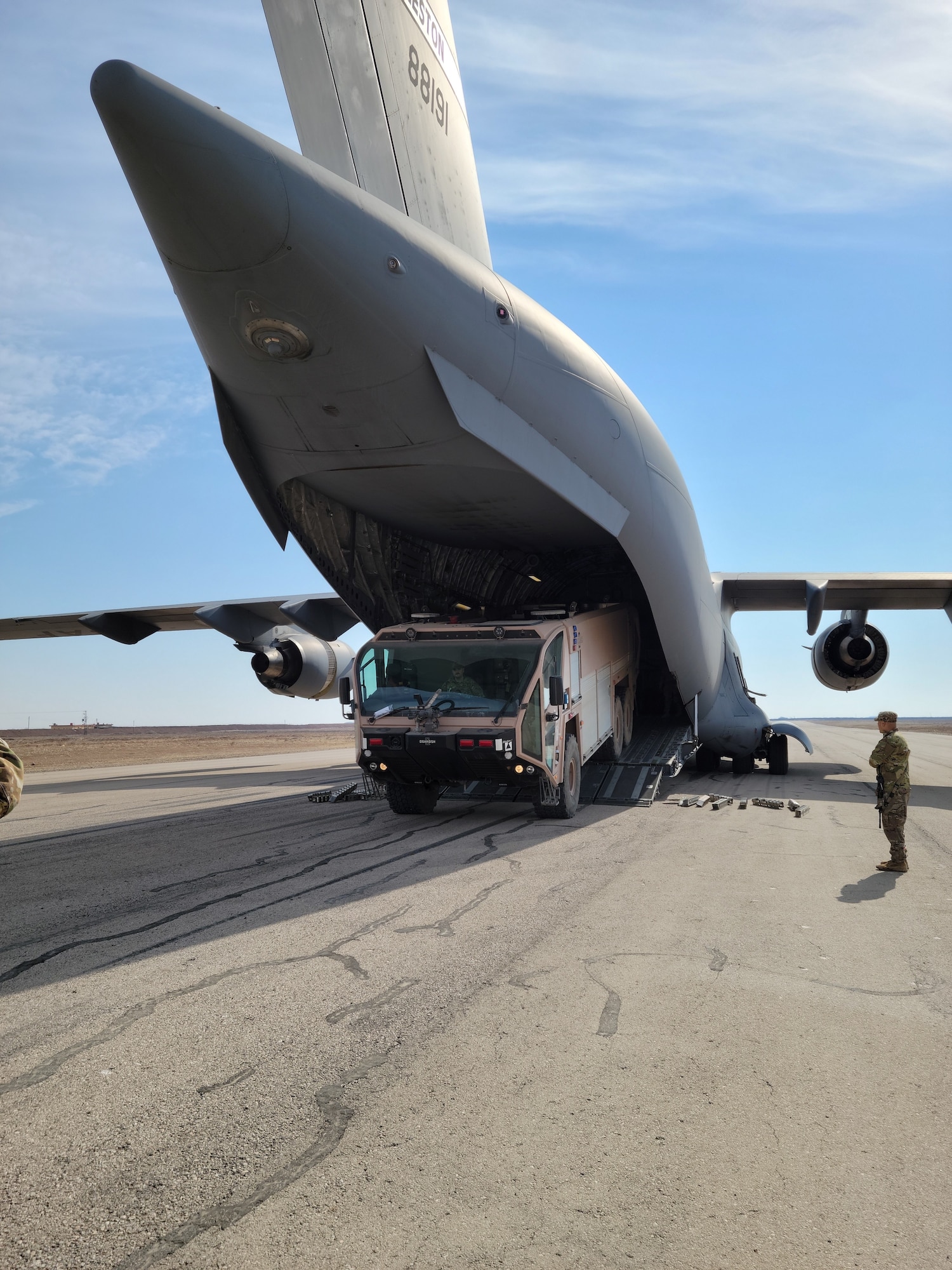 Airmen assigned to the 1st Expeditionary Theater Support Group off-load a P-19 Aircraft Rescue Fire Fighting vehicle from a C-17 Globemaster at an undisclosed location within the U.S. Central Command area of responsibility, Oct. 14, 2023. The Crash Fire Rescue Quick Strike Team conducted operations in Egypt, Syria, and other locations, enabling ACE air operations with an increased layer of safety for their fellow Airmen. (U.S. Air Force Courtesy Photo)