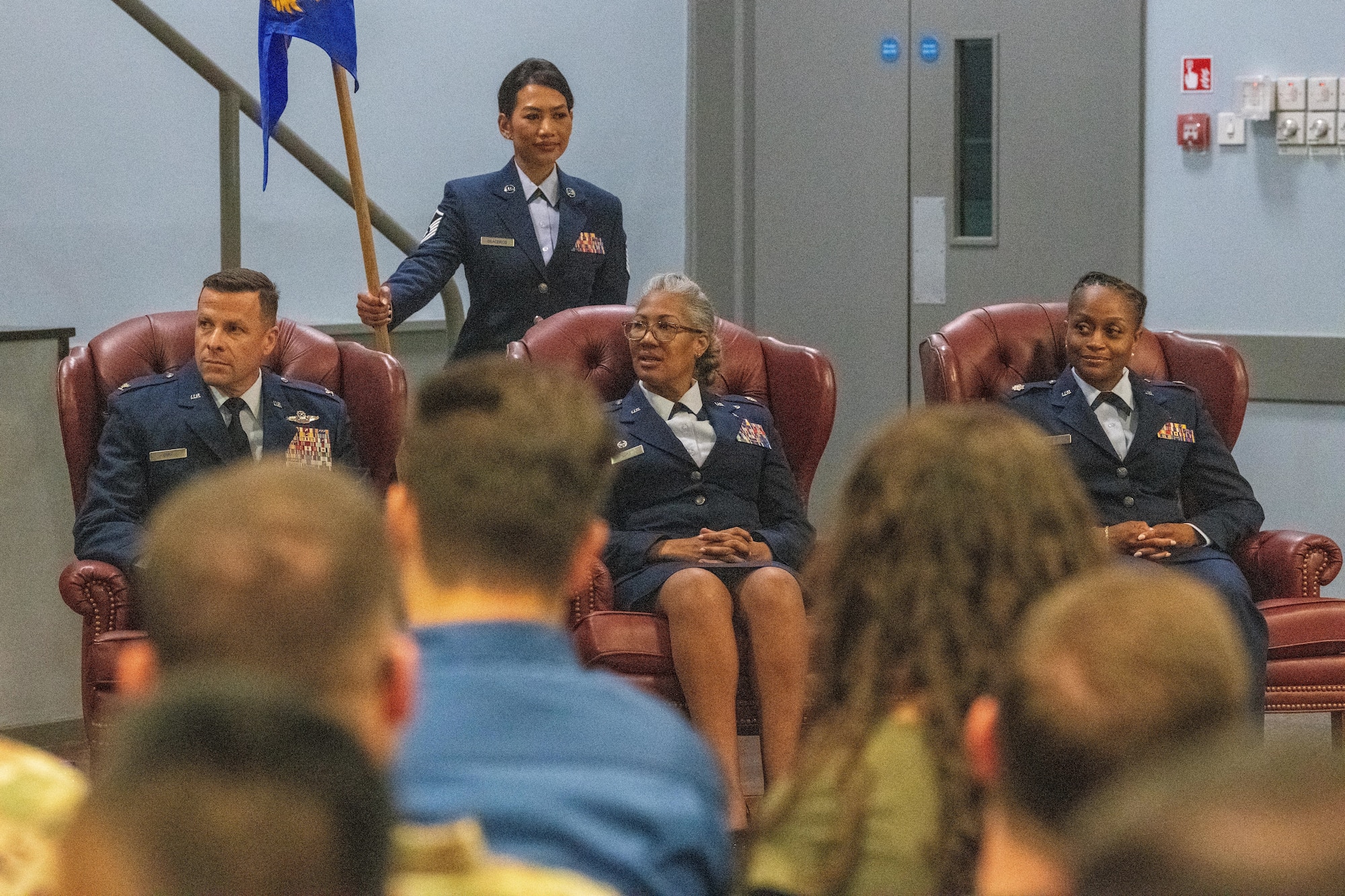 Airmen sit at the front of a ceremony