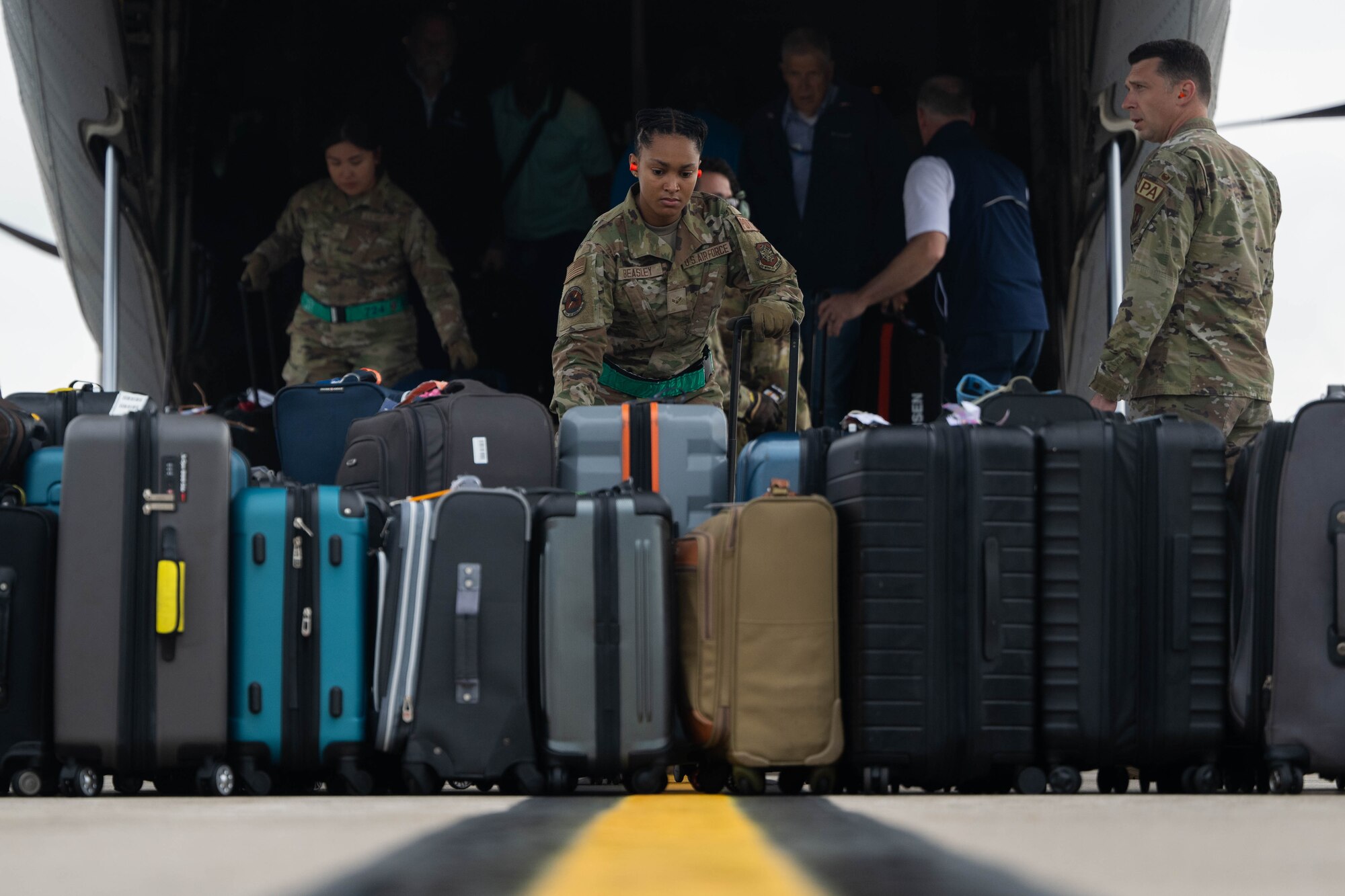 Airman 1st Class Charleah Beasley, 724th Air Mobility Squadron aircraft service specialist, unloads luggage.