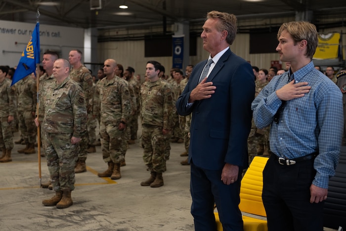 Jeffry Flake, U.S. Ambassador to Turkey, and his son Tanner Flake stand for the playing of the National Anthem during the 39th Air Base Wing change of command ceremony.