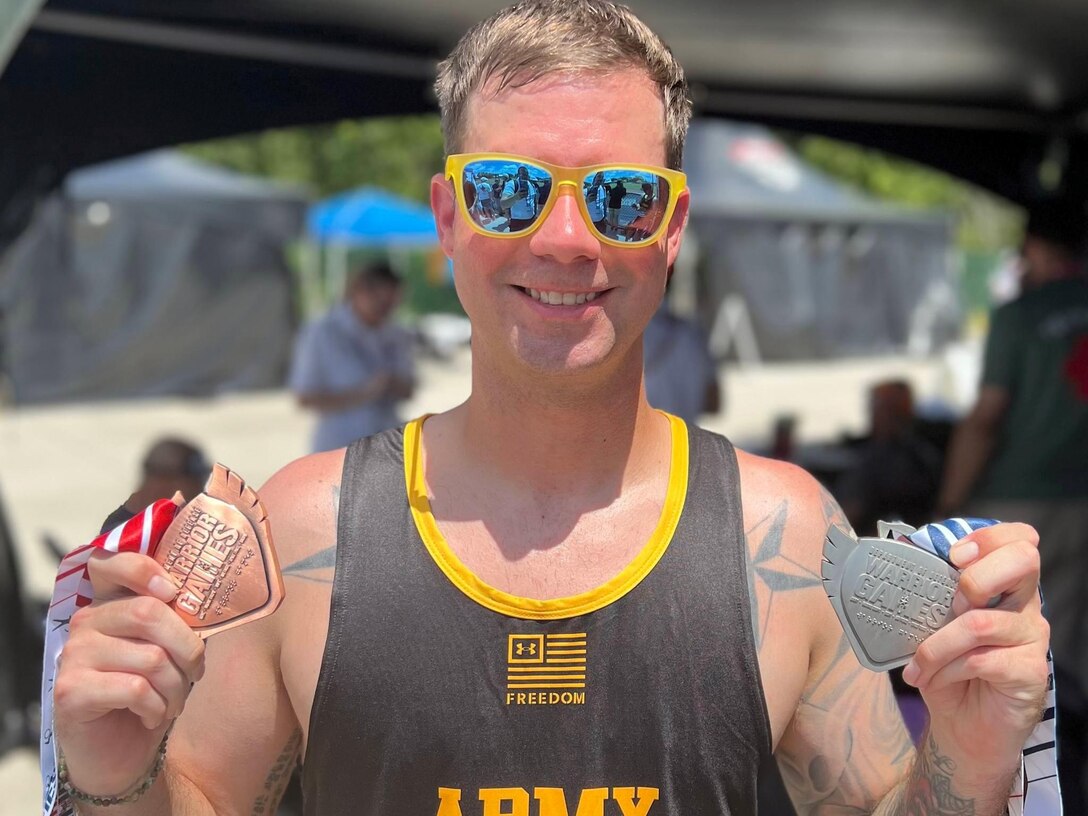 U.S. Army Staff Sgt. John Britton shows off his medals after competing in the track event