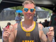 U.S. Army Staff Sgt. John Britton shows off his medals after competing in the track event