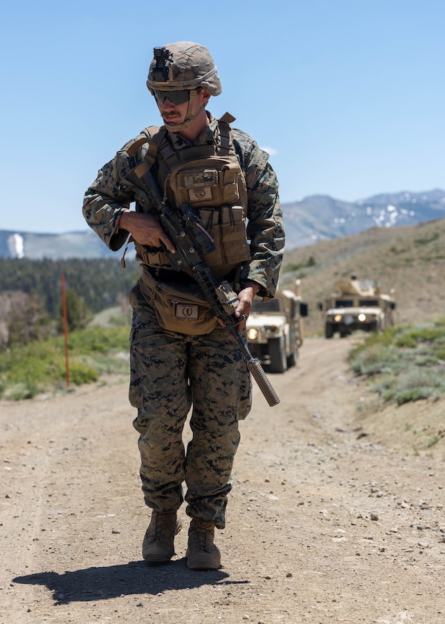 A U.S. Marine with 1st Battalion, 25th Marine Regiment, 4th Marine Division patrols in front of a vehicle convoy during the culminating event of Mountain Training Exercise 4-24 at Marine Corps Mountain Warfare Training Center, Bridgeport, California, June 23, 2024. Marines undergo a 72-hour evaluation testing them in tactics, techniques and procedures for mountain warfare. (U.S. Marine Corps photo by Staff Sgt. Jestin Costa)