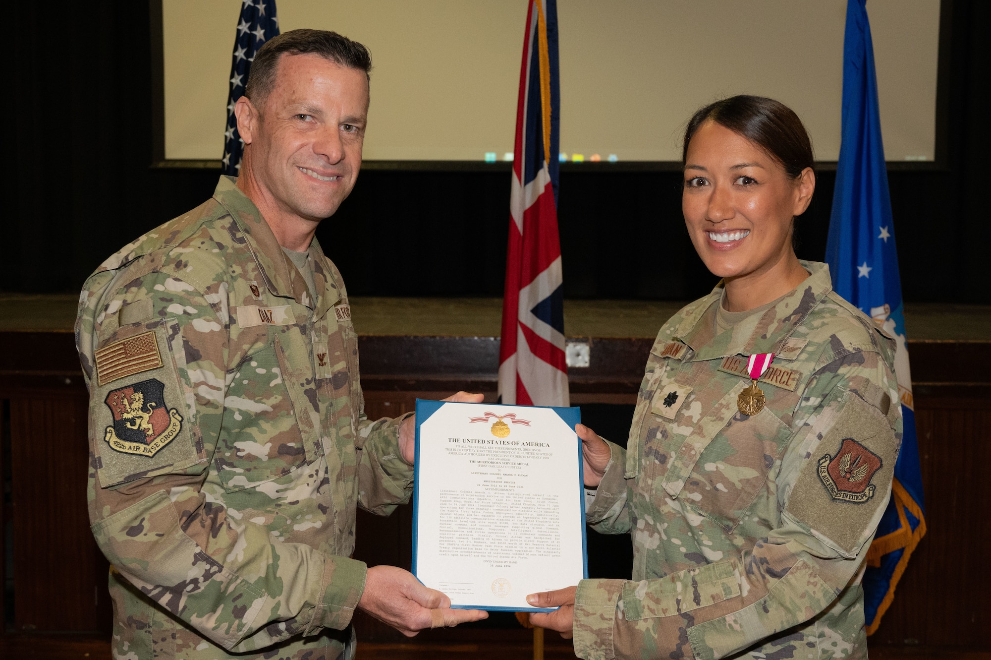 U.S. Air Force Col. Ricardo M. Diaz, left, 422nd Air Base Group commander, presents a meritorious service medal to Lt. Col. Amanda C. Altman, right, 422nd Communications Squadron outgoing commander.