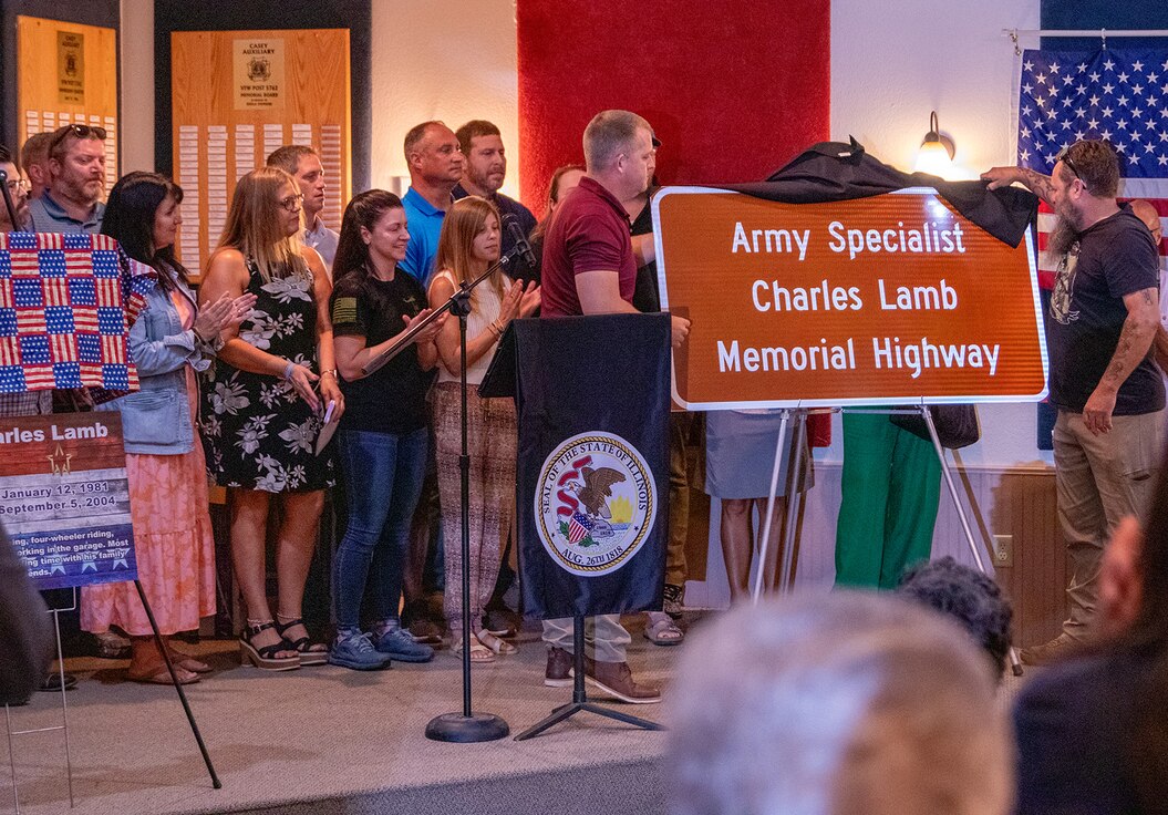 Illinois Army National Guard Soldiers who served in the 1544th Transportation Company’s 2004 deployment to Iraq unveil the road sign designating Highway 40 through Casey as the Army Specialist Charles Lamb Memorial Highway at a ceremony June 26 at Casey Veterans of Foreign Wars Post 5762 in Casey. Lamb, who grew up in Casey, was killed Sept. 5, 2004 during a mortar attack in Baghdad, Iraq.