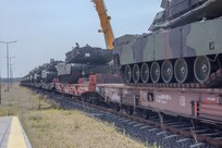 Multiple M1 Abrams tanks wait to be moved from a rail car to the staging area at the Powidz APS-2 Worksite, Powidz, Poland on June 27, 2024. The newly arrived vehicles and equipment will serve as a prepositioned stock for armored brigades deploying or training in the European region, specifically in Poland. 

(U.S. Army photo by Capt. Michael Mastrangelo)