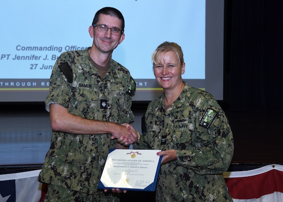 JOINT BASE SAN ANTONIO-FORT SAM HOUSTON – (June 27, 2024) – Cmdr. Nicholas Hamlin (Dental Corps), the prospective executive officer assigned to Naval Medical Research Unit (NAMRU) San Antonio, was presented with the Meritorious Service Medal by Commanding Officer Capt. Jennifer Buechel (Nurse Corps) during an All Hands meeting held at the Military and Family Readiness Center.  NAMRU San Antonio is one of the leading research and development laboratories for the U.S. Navy under the Department of Defense and is one of eight subordinate research commands in the global network of laboratories operating under the Naval Medical Research Center in Silver Spring, Md.  Its mission is to conduct gap driven combat casualty care, craniofacial, and directed energy research to improve survival, operational readiness, and safety of DOD personnel engaged in routine and expeditionary operations. (U.S. Navy photo by Burrell Parmer, NAMRU San Antonio Public Affairs/Released)