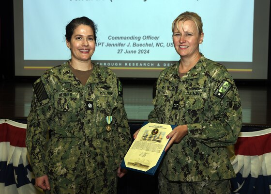 JOINT BASE SAN ANTONIO-FORT SAM HOUSTON – (June 27, 2024) – Cmdr.  Rachel Werner (Dental Corps), deputy chief science director assigned to Naval Medical Research Unit (NAMRU) San Antonio, was awarded the Military Outstanding Volunteer Service Medal by Commanding Officer Capt. Jennifer Buechel (Nurse Corps) during an All Hands meeting held at the Military and Family Readiness Center.    NAMRU San Antonio is one of the leading research and development laboratories for the U.S. Navy under the Department of Defense and is one of eight subordinate research commands in the global network of laboratories operating under the Naval Medical Research Center in Silver Spring, Md.  Its mission is to conduct gap driven combat casualty care, craniofacial, and directed energy research to improve survival, operational readiness, and safety of DOD personnel engaged in routine and expeditionary operations. (U.S. Navy photo by Burrell Parmer, NAMRU San Antonio Public Affairs/Released)