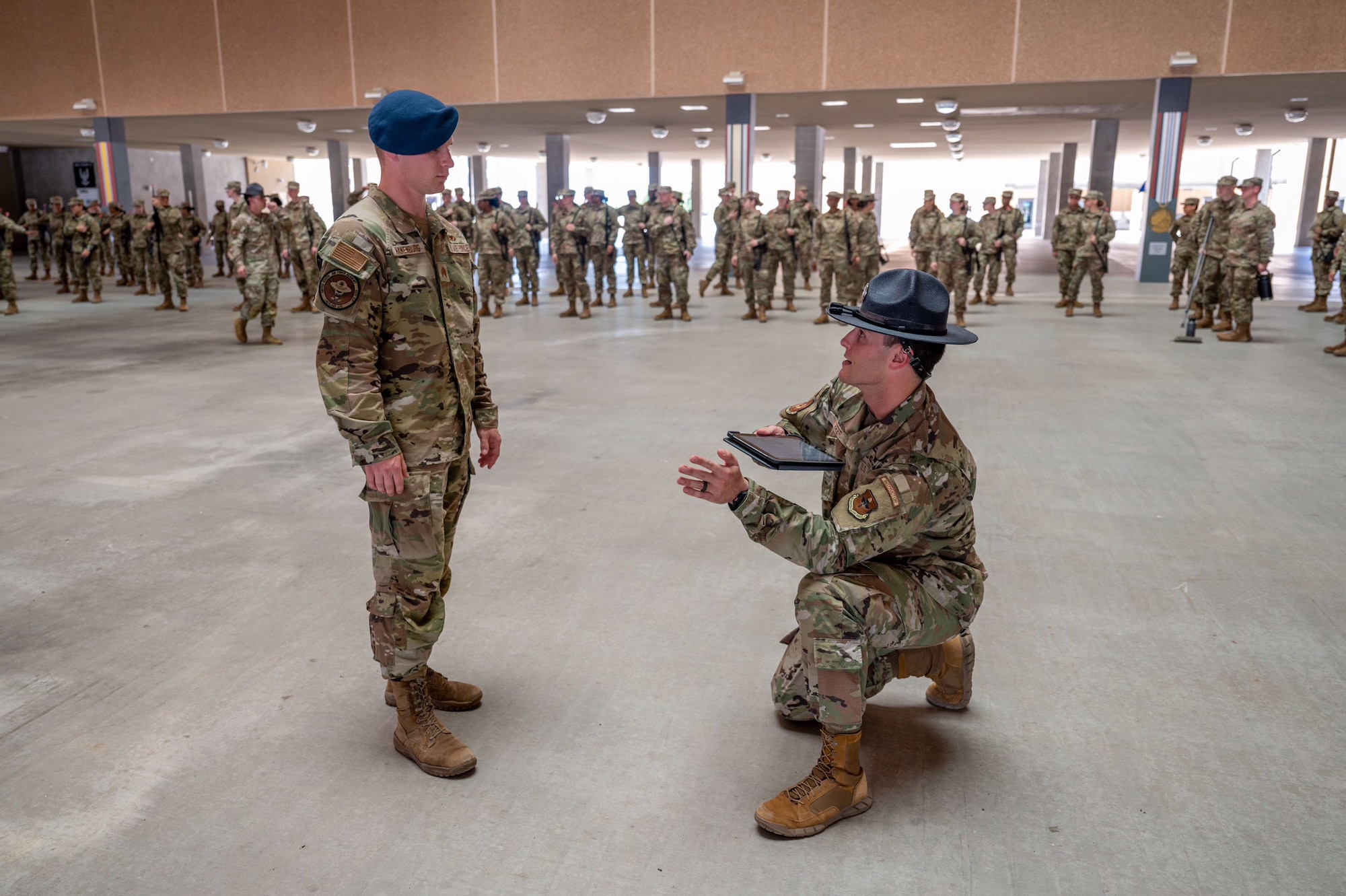 Tech. Sgt. Brian Weber, a Military Training Instructor with the 321st Training Squadron, provides guidance to U.S. Air Force Academy Cadet 2nd Class Seth Hanenburg during a weapons handling lesson for Basic Military Training trainees on June 17, 2024, at Joint Base San Antonio-Lackland, Texas. The Summer Leadership Program at USAFA provides cadets with the opportunity to collaborate with BMT MTIs at the 737th Training Group for three weeks in June. When the cadets return to USAFA in the fall, they will lead the six-week indoctrination program, Basic Cadet Training, for incoming USAFA students. The 321 TRS, is just one of 10 training squadrons, that guide and coach the next generation of Airmen at BMT. (U.S. Air Force photo by Ava Leone)