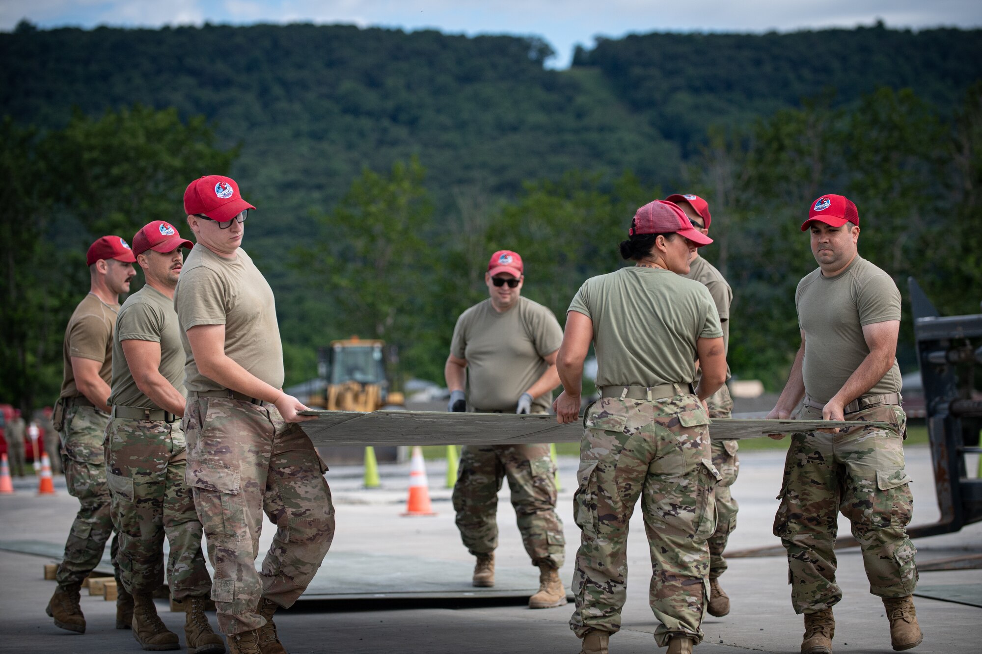Airmen from the 201st RED HORSE Squadron connect fiber reinforced polymer panels to simulate repairing an aircraft runway during Pennsylvania Air National Guard exercise Iron Keystone 24 at Fort Indiantown Gap, Pennsylvania, June 9, 2024.