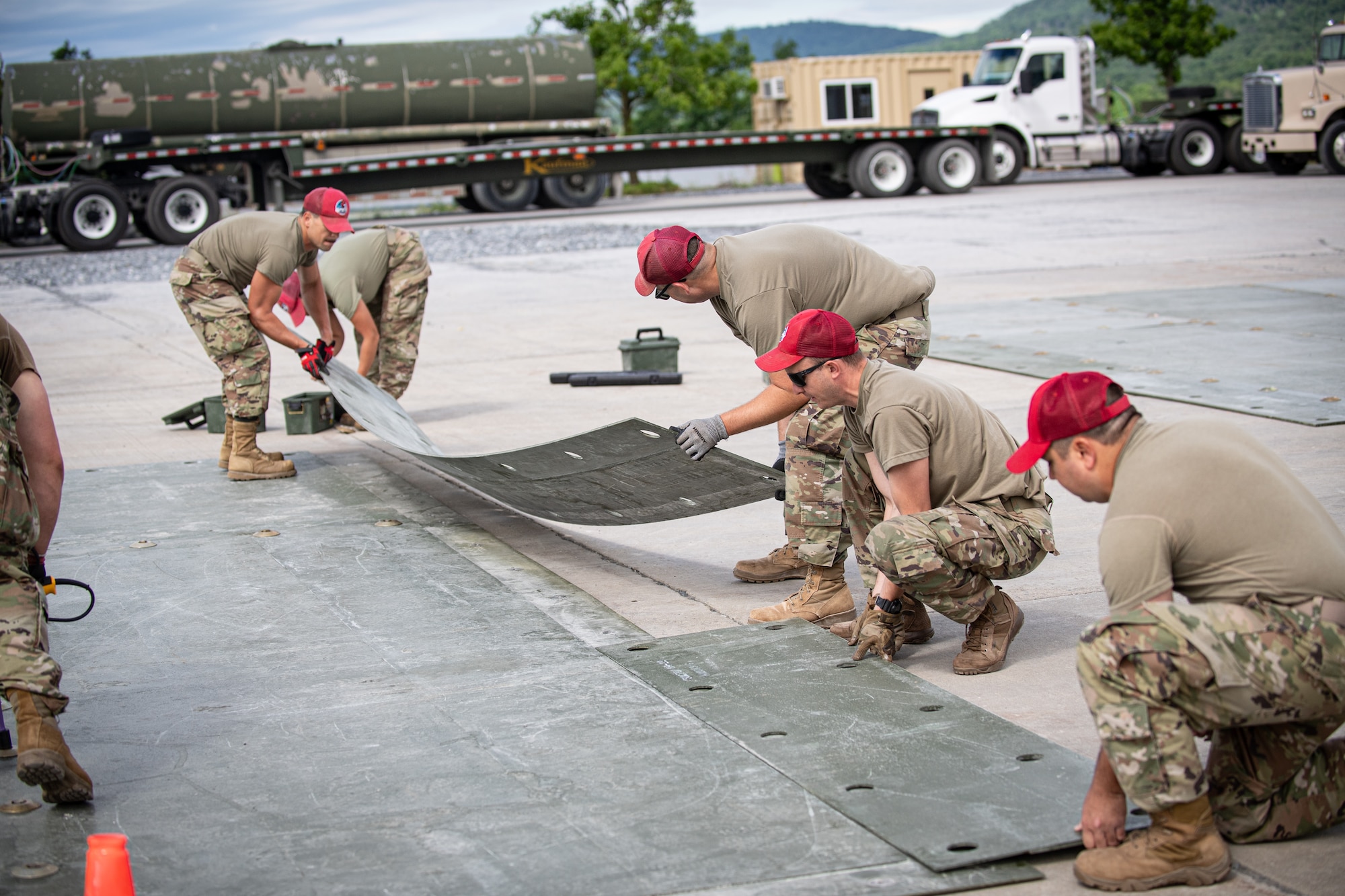 Airmen from the 201st RED HORSE Squadron connect fiber reinforced polymer panels to simulate repairing an aircraft runway during Pennsylvania Air National Guard exercise Iron Keystone 24 at Fort Indiantown Gap, Pennsylvania, June 9, 2024.
