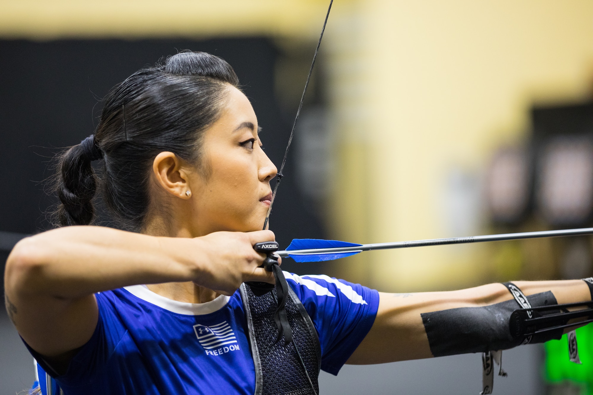 Retired Capt. Christina Kang, Team Air Force athlete, readies her bow to fire an arrow at her target during archery familiarization