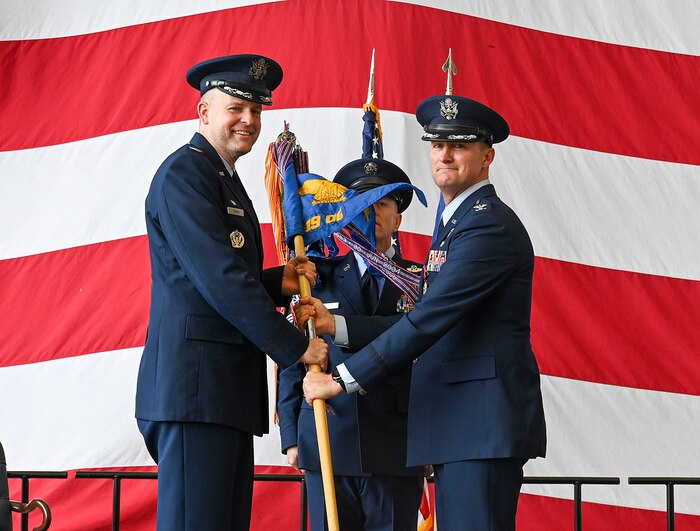 A group commander passes a guidon to the wing commander