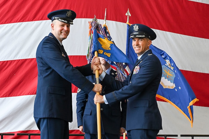 The wing commander passes a guidon to a group commander