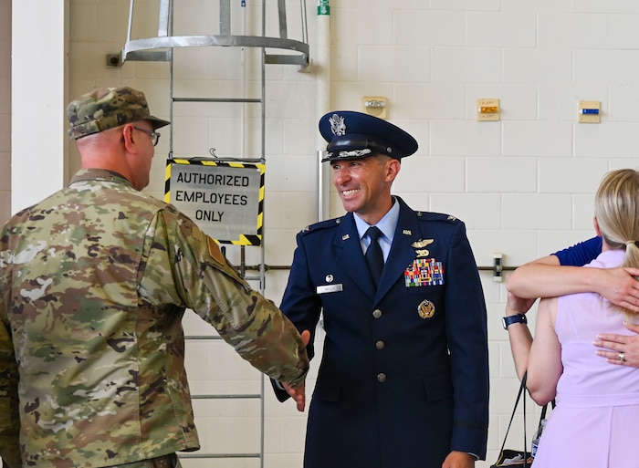 An Airman shakes hands with the new commander of the 19th Operations Group