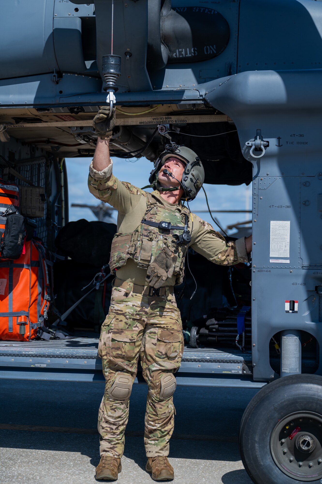 U.S. Air Force Senior Airman Ben Spivey, 41st Rescue Squadron HH-60W special mission aviator from Moody Air Force Base, Georgia, grabs the rescue hoist system on a helicopter at Patrick Space Force Base, Florida, June 1, 2024. The team from Moody supported the Atlas V rocket Orbital Crew Flight Test mission, which launched two astronauts from Space Launch Complex 41 on Cape Canaveral Space Force Station, Florida. This was the first time since 1968 astronauts were launched from CCSFS and the first time ever from a Space Force installation. (U.S. Space Force photo by Airman 1st Class Spencer Contreras)