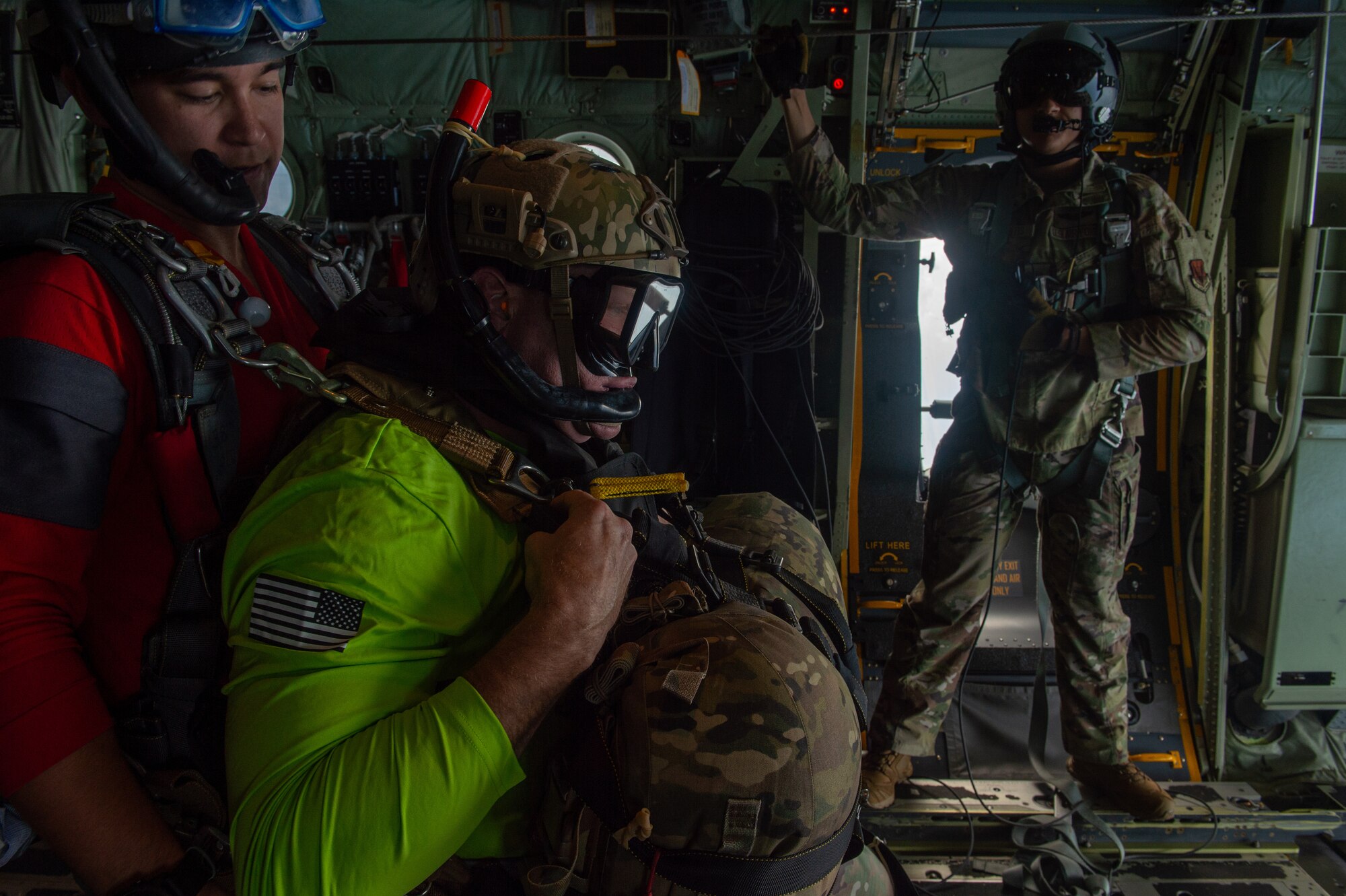 U.S. Air Force Chief Master Sgt. Justin Geers, middle, 23rd Wing command chief, prepares for a tandem jump with a pararescueman assigned to the 38th Rescue Squadron over the Gulf of Mexico, June 24, 2024. The pararescuemen stationed at Moody Air Force Base, Georgia, utilize both the HH-60W Jolly Green II and HC-130J Combat King II to execute their prime mission of saving the lives of others. (U.S. Air Force photo by Airman 1st Class Iain Stanley)