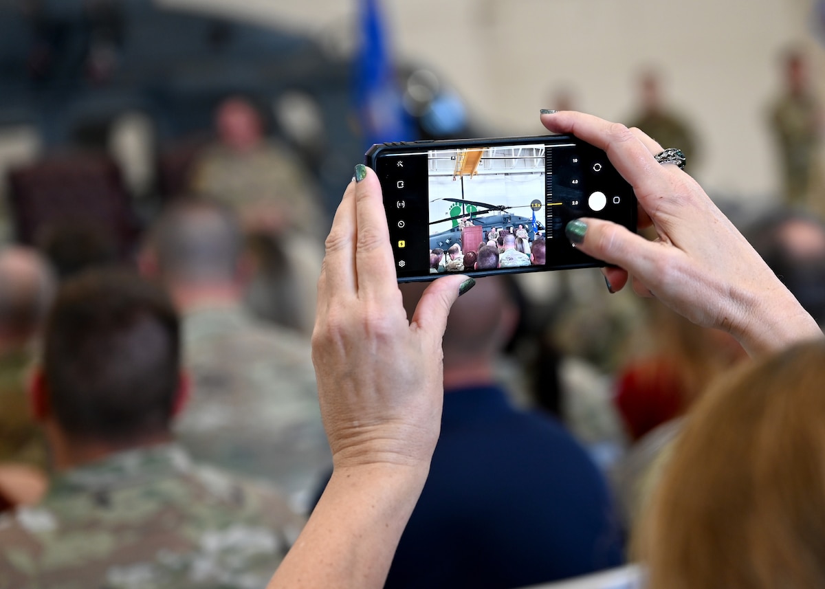 An attendee takes a photo during the 563rd Rescue Group Change of Command at Davis-Monthan Air Force Base, Ariz., June 28, 2024. The 563rd RQS directs flying operations for one of the U.S. Air Force's only active duty rescue wings dedicated to combat search and rescue. (U.S. Air Force photo by Staff Sgt. Abbey Rieves)