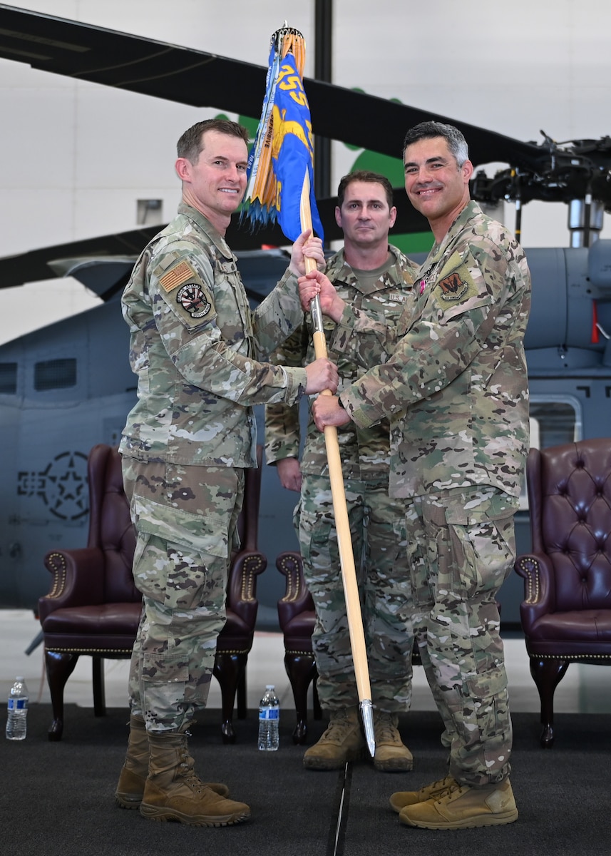 U.S. Air Force Col. Scott Mills, 355th Wing commander, left, presents Col. Jose Cabrera, 563rd Rescue Group outgoing commander, right, the meritorious service medal during the 563rd RQG Change of Command at Davis-Monthan Air Force Base, Ariz., June 28, 2024. Cabrera was responsible for the overall combat training and readiness of more than 650 personnel at the 563rd. (U.S. Air Force photo by Staff Sgt. Abbey Rieves)