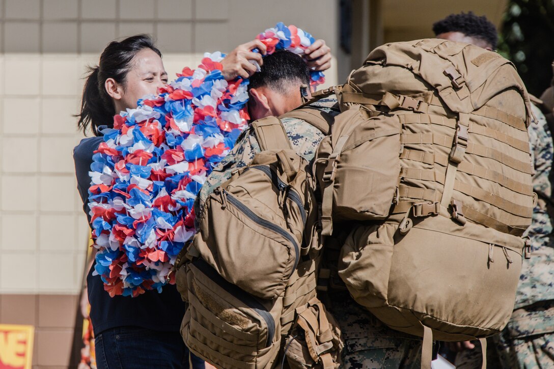 A U.S. Marine with 3d Marine Littoral Regiment, 3d Marine Division, receives a lei from a USO volunteer during a homecoming event at Marine Corps Base Hawaii, June 26, 2024. The homecoming event was held for the Marines returning from the Philippines following their support in Exercise Balikatan 24 and Marine Aviation Support Activity 24. (U.S. Marine Corps photo by Sgt. Grace Gerlach)