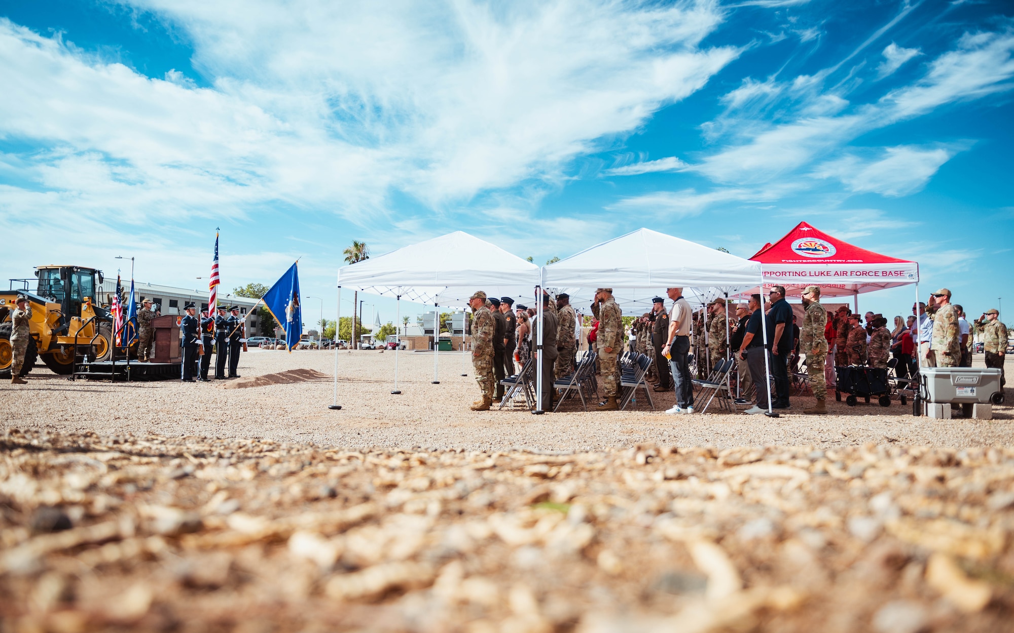 U.S. Air Force Airmen, leadership, and Fighter Country Foundation members, stand for the national anthem during a groundbreaking ceremony for the new base Honor Guard facility.
