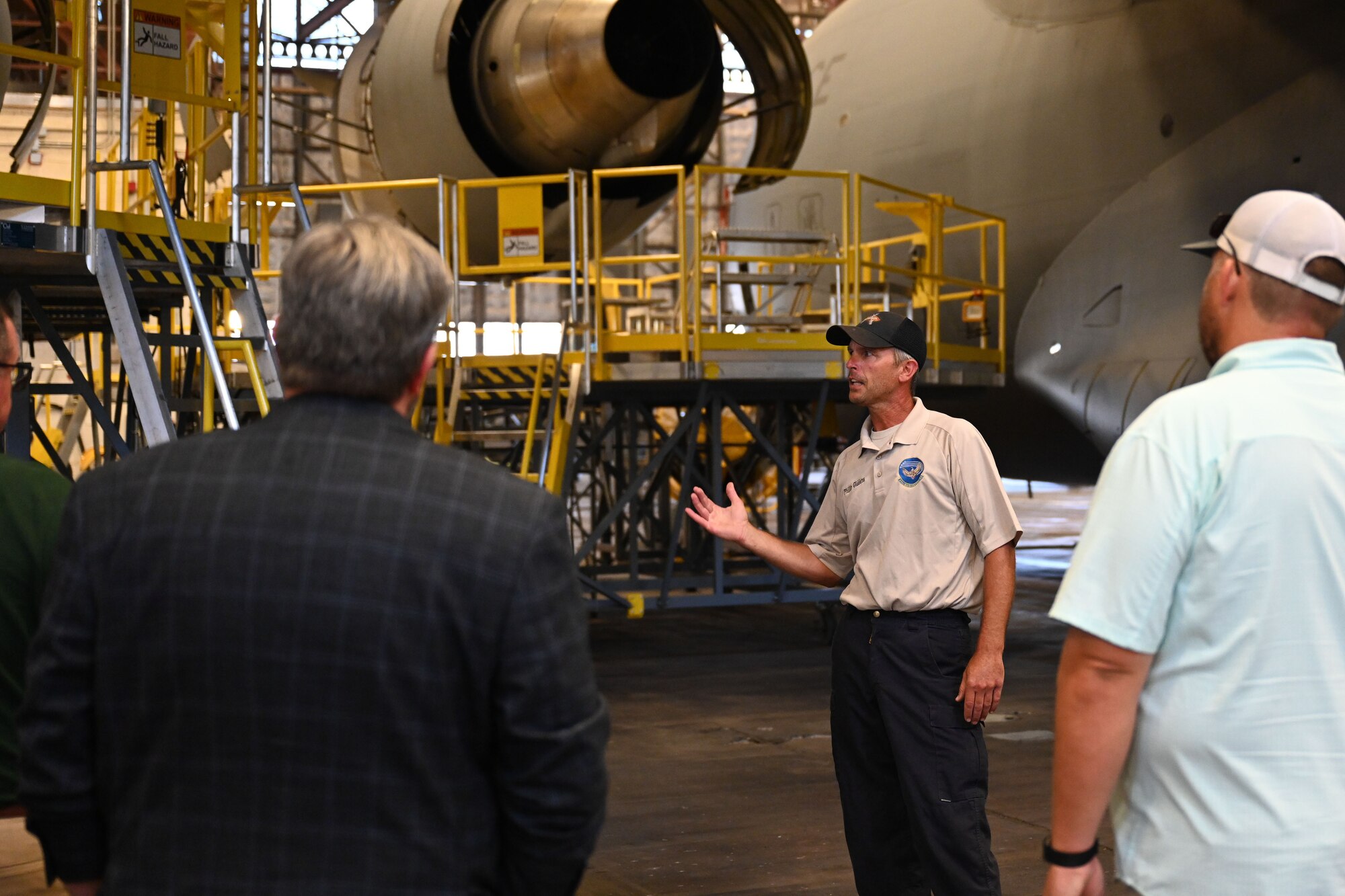 Phillip Giddens, 97th Maintenance Squadron day shift inspection flight supervisor, briefs Altus Air Force Base (AFB) honorary commanders on the engine of a C-17 Globemaster III aircraft inside Hangar 285 at Altus AFB, Oklahoma, June 11, 2024. Each engine of the C-17 is rated at 40,440 pounds of thrust. (U.S. Air Force photo by Airman 1st Class Jonah G. Bliss)