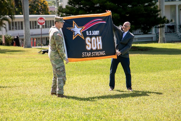 Lt. Col. Christopher “Ryan” Pevey, Honolulu District commander, receives the Safety and Occupational Health Star flag from Troy Larson, Headquarters U.S. Army Corps of Engineers Safety and Occupational Health Manager during a ceremony to present the prestigious Army Safety and Occupational Health Star Award to the Honolulu District, U.S. Army Corps of Engineers on Fort Shafter June 28, 2024. Honolulu District is the first district within the Pacific Ocean Division, and fourth organization in the Army, to achieve this recognition from the Assistant Secretary of the Army.