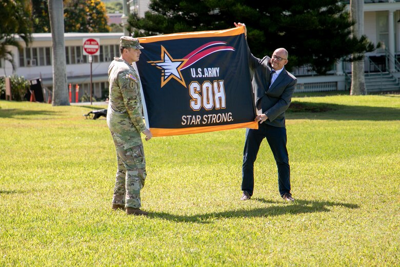 Lt. Col. Christopher “Ryan” Pevey, Honolulu District commander, receives the Safety and Occupational Health Star flag from Troy Larson, Headquarters U.S. Army Corps of Engineers Safety and Occupational Health Manager during a ceremony to present the prestigious Army Safety and Occupational Health Star Award to the Honolulu District, U.S. Army Corps of Engineers on Fort Shafter June 28, 2024. Honolulu District is the first district within the Pacific Ocean Division, and fourth organization in the Army, to achieve this recognition from the Assistant Secretary of the Army.