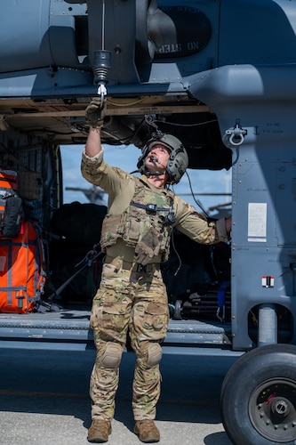 U.S. Air Force Senior Airman Ben Spivey, 41st Rescue Squadron HH-60W special mission aviator from Moody Air Force Base, Georgia, grabs the rescue hoist system on a helicopter at Patrick Space Force Base, Florida, June 1, 2024. The team from Moody supported the Atlas V rocket Orbital Crew Flight Test mission, which launched two astronauts from Space Launch Complex 41 on Cape Canaveral Space Force Station, Florida. This was the first time since 1968 astronauts were launched from CCSFS and the first time ever from a Space Force installation. (U.S. Space Force photo by Airman 1st Class Spencer Contreras)