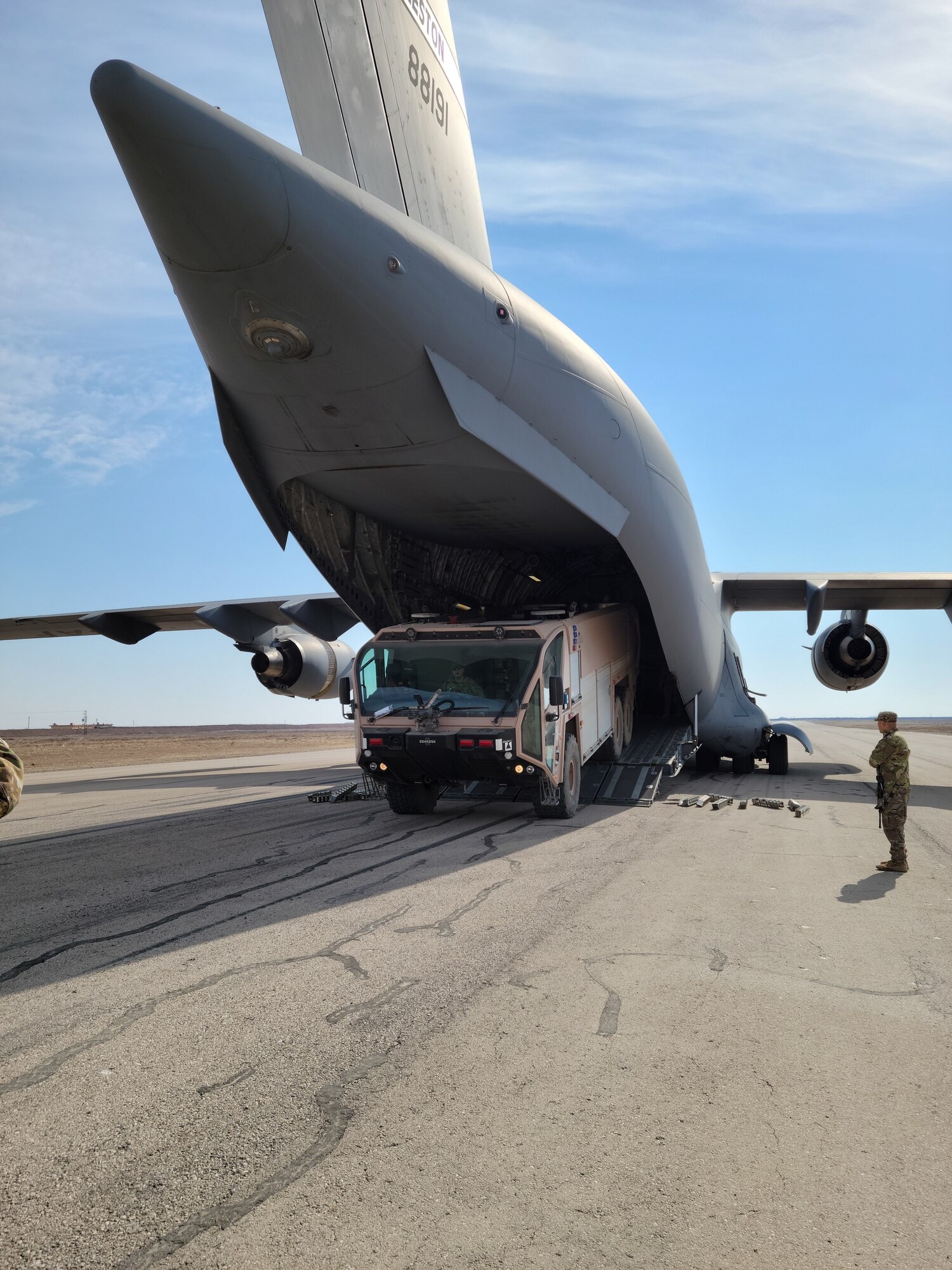 Airmen assigned to the 1st Expeditionary Theater Support Group off-load a P-19 Aircraft Rescue Fire Fighting vehicle from a C-17 Globemaster at an undisclosed location within the U.S. Central Command area of responsibility, Oct. 14, 2023. The Crash Fire Rescue Quick Strike Team conducted operations in Egypt, Syria, and other locations, enabling ACE air operations with an increased layer of safety for their fellow Airmen. (U.S. Air Force Courtesy Photo)