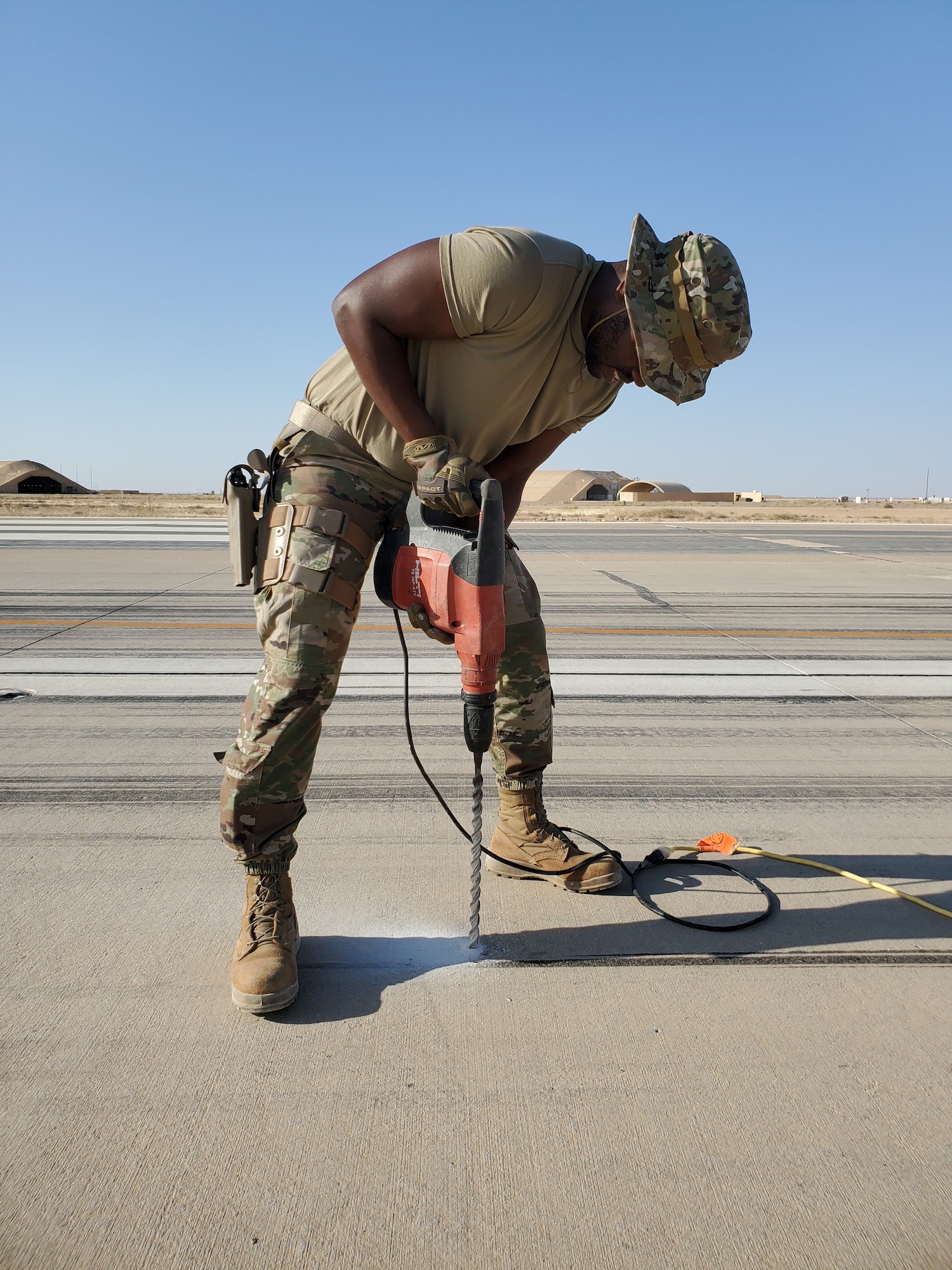 An Airman assigned to the 1st Expeditionary Theater Support Group drills a hole through concrete at an undisclosed location within the U.S. Central Command area of responsibility, Oct. 11, 2023. The ETSG is responsible for the management, coordination, and Partner Nation engagement for $11B in host-nation funded construction. (U.S. Air Force Courtesy photo)