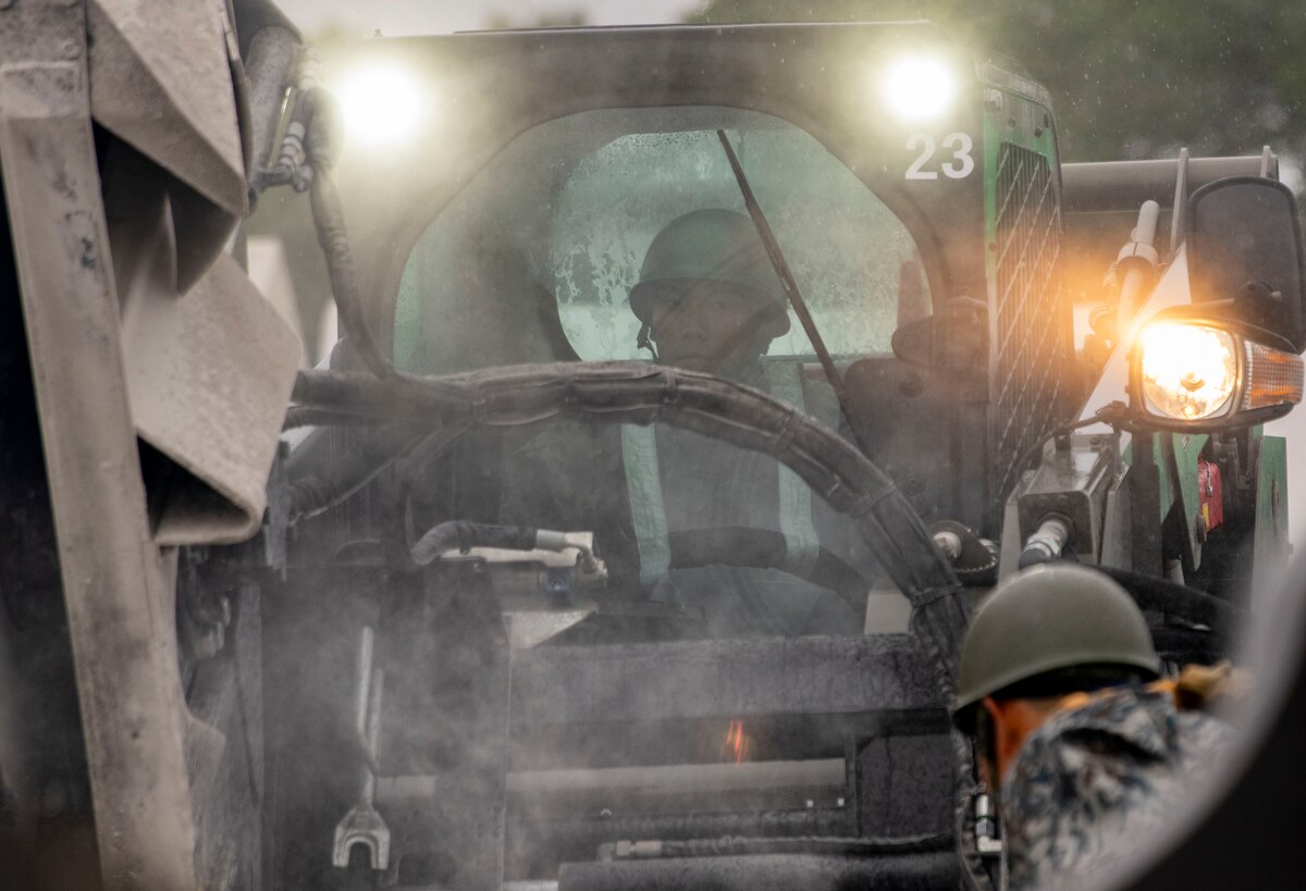 A Japan Air Self-Defense Force member is inside of a saw cutter.