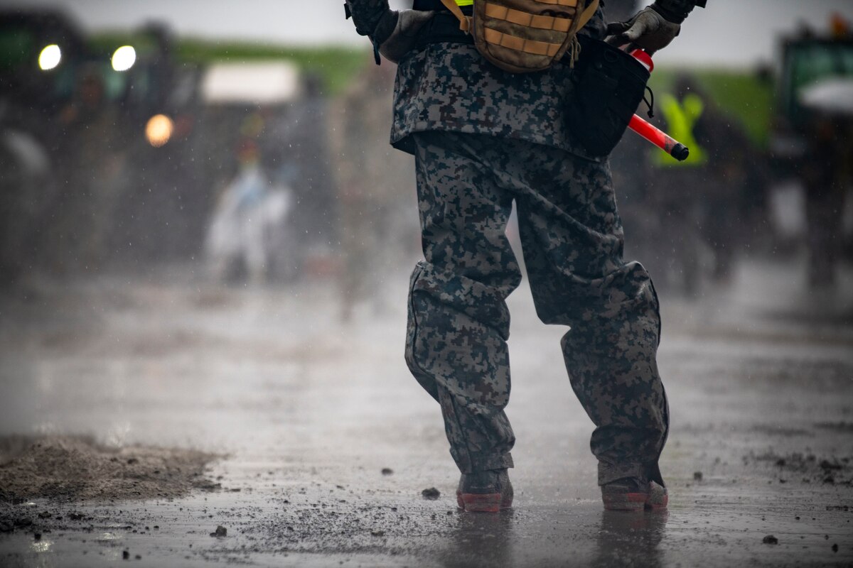 A Japan Air Self-Defense Force member stands in the rain.