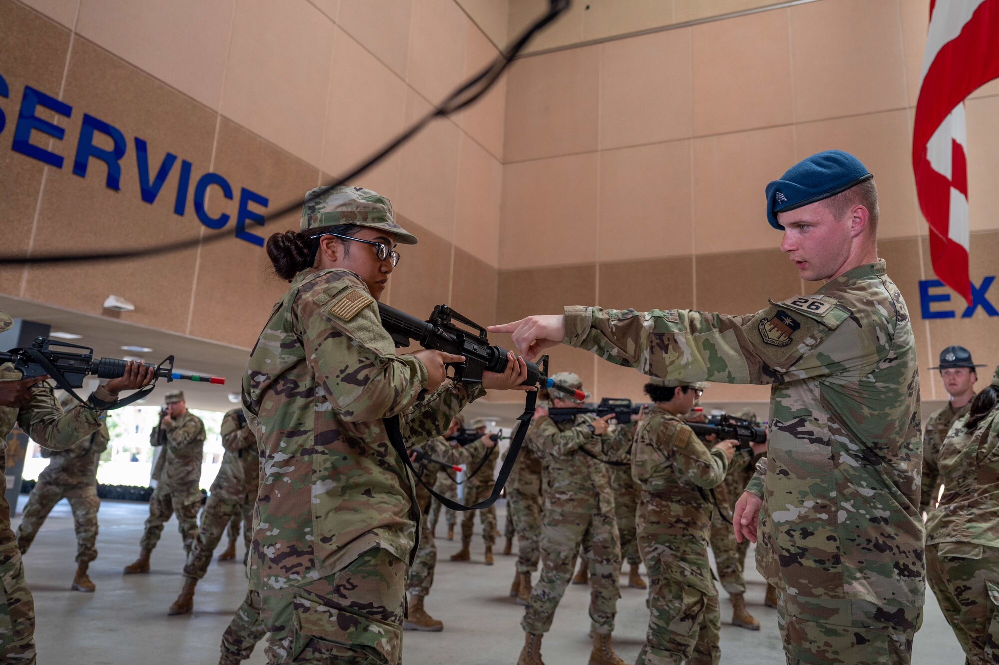 Cadet 2nd Class Seth Hanenburg (right) with the U.S. Air Force Academy instructs a Basic Military Training trainee with the 321st Training Squadron on how to hold a weapon during a weapons handling lesson on June 17, 2024, at Joint Base San Antonio-Lackland, Texas. The Summer Leadership Program at USAFA provides cadets with the opportunity to collaborate with BMT MTIs at the 737th Training Group for three weeks in June. When the cadets return to USAFA in the fall, they will lead the six-week indoctrination program, Basic Cadet Training, for incoming USAFA students. The 321 TRS, is just one of 10 training squadrons, that guide and coach the next generation of Airmen at BMT. (U.S. Air Force photo by Ava Leone)