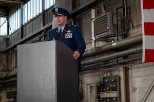 An Air Force officer in dress blues speaks from behind a podium