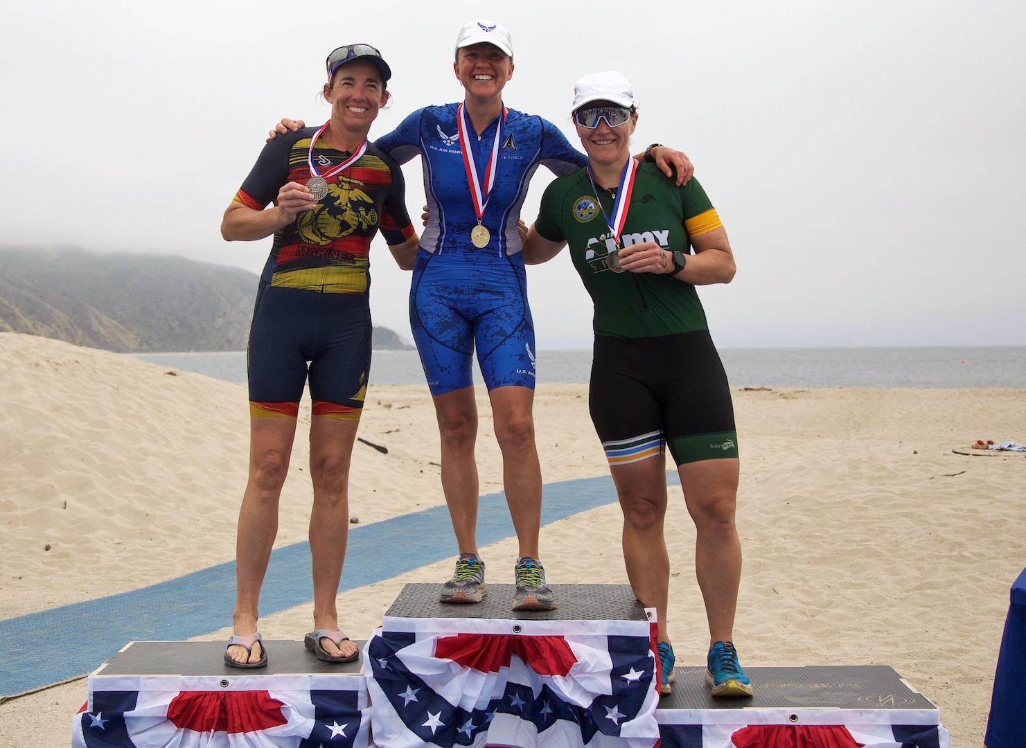 From left to right:  Marine Col. Christine Houser of MCB Camp Pendelton; Air Force Major Esther Willet of F.E. Warren AFB, Wyoming; and Army Major Christyn Gaa of Fort Bliss, Texas on top of the podium for the Armed Forces Women's Masters Division of the 2024 Armed Forces Triathlon Championships was held at Naval Base Ventura County, Calif., June 26-30. Service members from Army, Marine Corps, Navy (with Coast Guard) and Air Force (with Space Force) battled alongside the Canadian forces for gold. (U.S. Army photo by Master Sgt. Sharilyn Wells/USACAPOC(A) PAO)