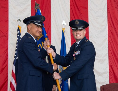 Airmen pass each other the squadron flag.