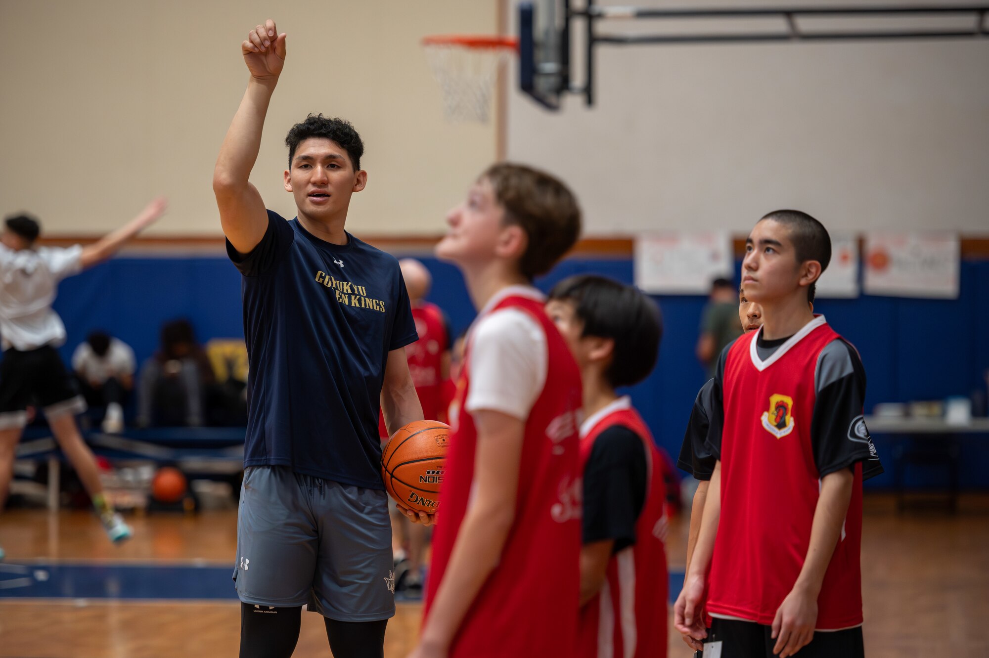 basketball player mentors students during a bilateral basketball camp