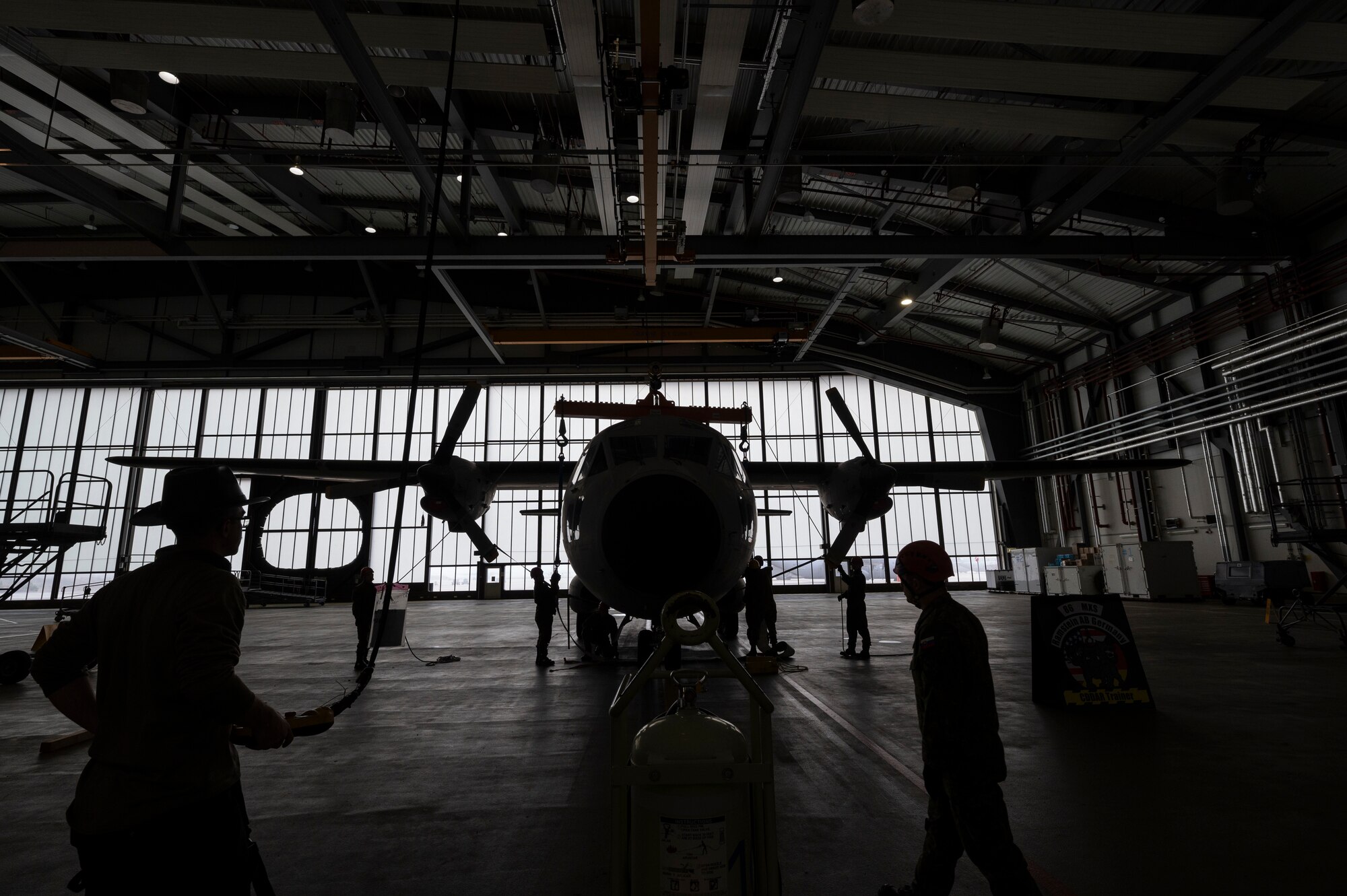A silhouette of a plane and people around it