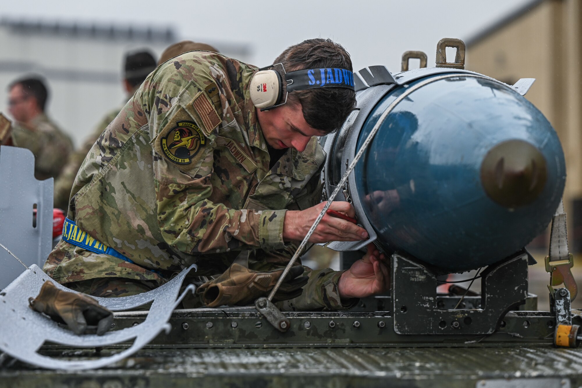 U.S. Air Force Airman 1st Class Shea Jadwin, a conventional maintenance crew chief assigned to the 4th Munitions Squadron, competes in an annual weapons load competition at Seymour Johnson Air Force Base, North Carolina, Feb. 23, 2024. Every year, a load crew from each unit goes head-to-head in a competition that tests their dress and appearance, weapons knowledge and speed and accuracy of loading munitions on an F-15E Strike Eagle. (U.S. Air Force photo by Staff Sgt. Koby I. Saunders)