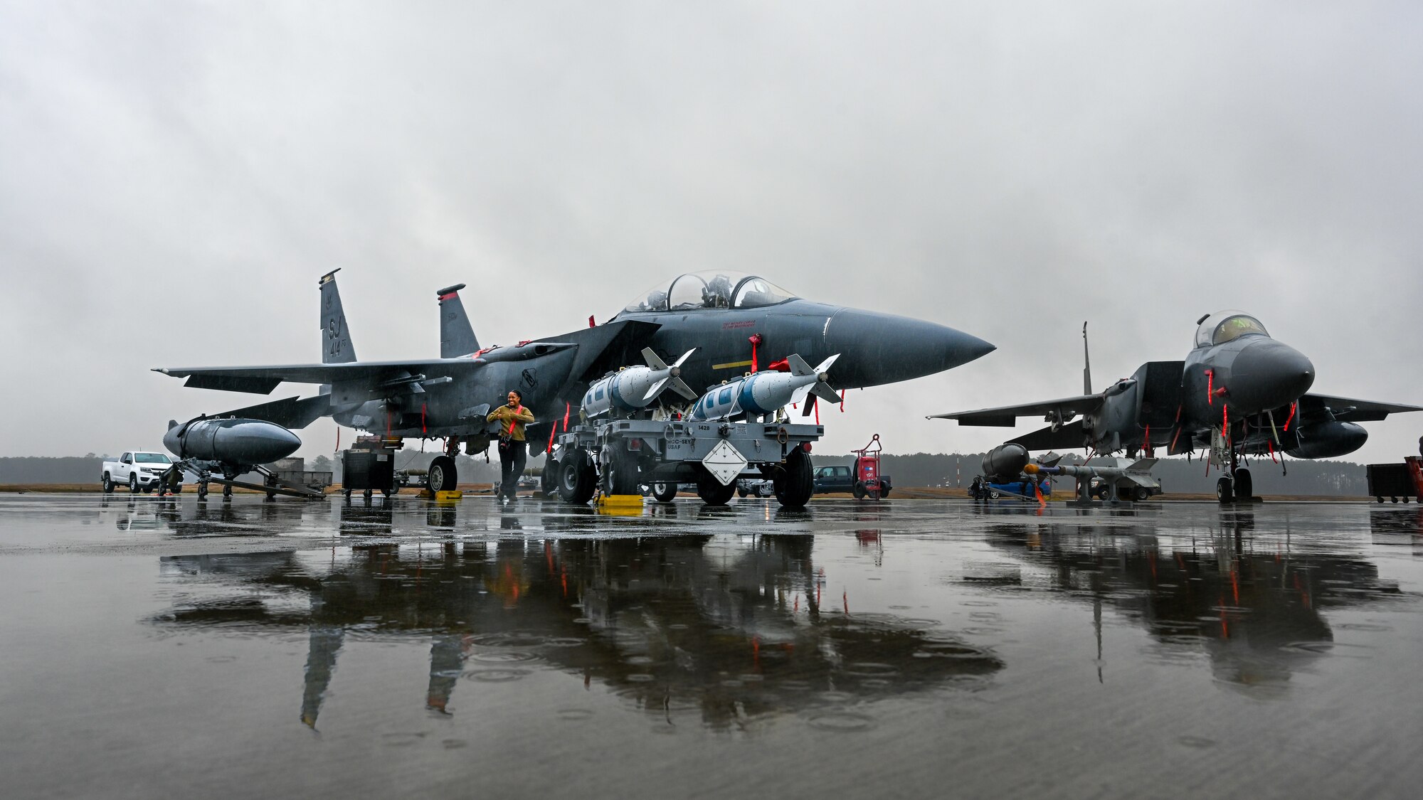 U.S. Air Force F-15E’s are staged on the flightline for an annual load crew competition at Seymour Johnson Air Force Base, North Carolina, on February 23, 2024. Every year, a load crew from each unit goes head-to-head in a competition that tests their dress and appearance, weapons knowledge and speed and accuracy of loading munitions on an F-15E Strike Eagle. (U.S. Air Force photo by Staff Sgt. Koby I. Saunders)