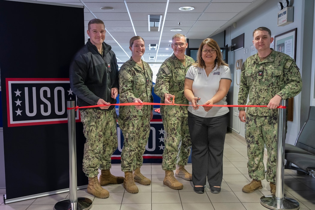 Sailors assigned to Naval Support Activity (NSA) Souda Bay and Sabrina Pullido, area director, United Service Organizations (USO), cut a ceremonial ribbon during the USO Center’s grand opening in the NSA Souda Bay Air Terminal on Feb. 29, 2024.