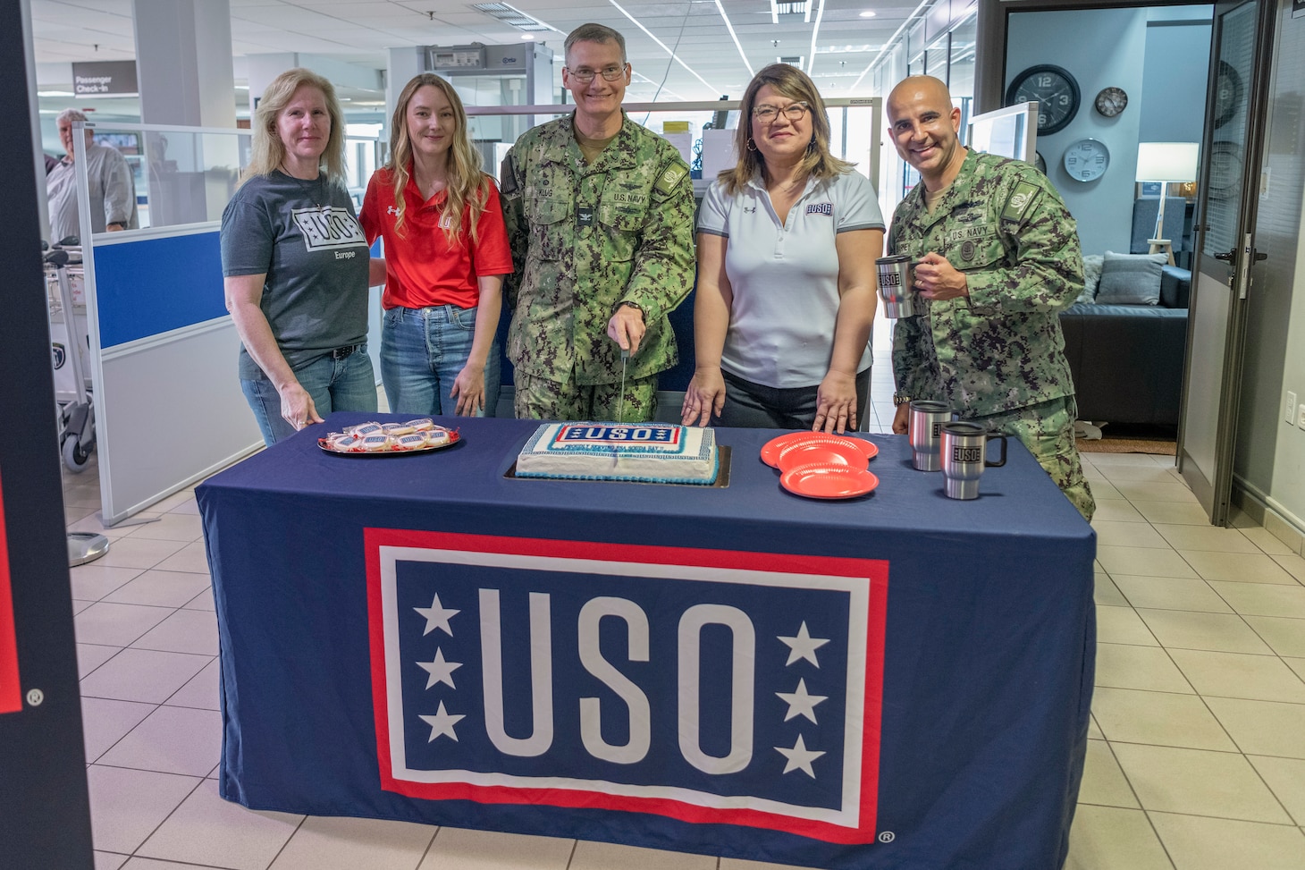 Personnel assigned to Naval Support Activity Souda Bay and United Service Organizations (USO) representatives cut a ceremonial ribbon during the USO Center’s grand opening in the NSA Souda Bay Air Terminal on Feb. 29, 2024.