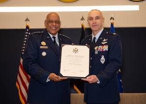 General cotton and Colonel Buzzell pose with a retirement certificate